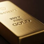 Stacks of gold bars with rising price chart in background