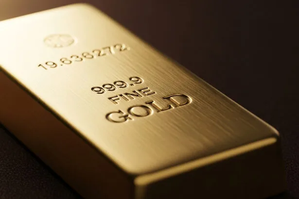 Stacks of gold bars with rising price chart in background